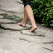 Füsse auf Gehwegsteinen im Garten Füsse auf Gehwegsteinen im Garten